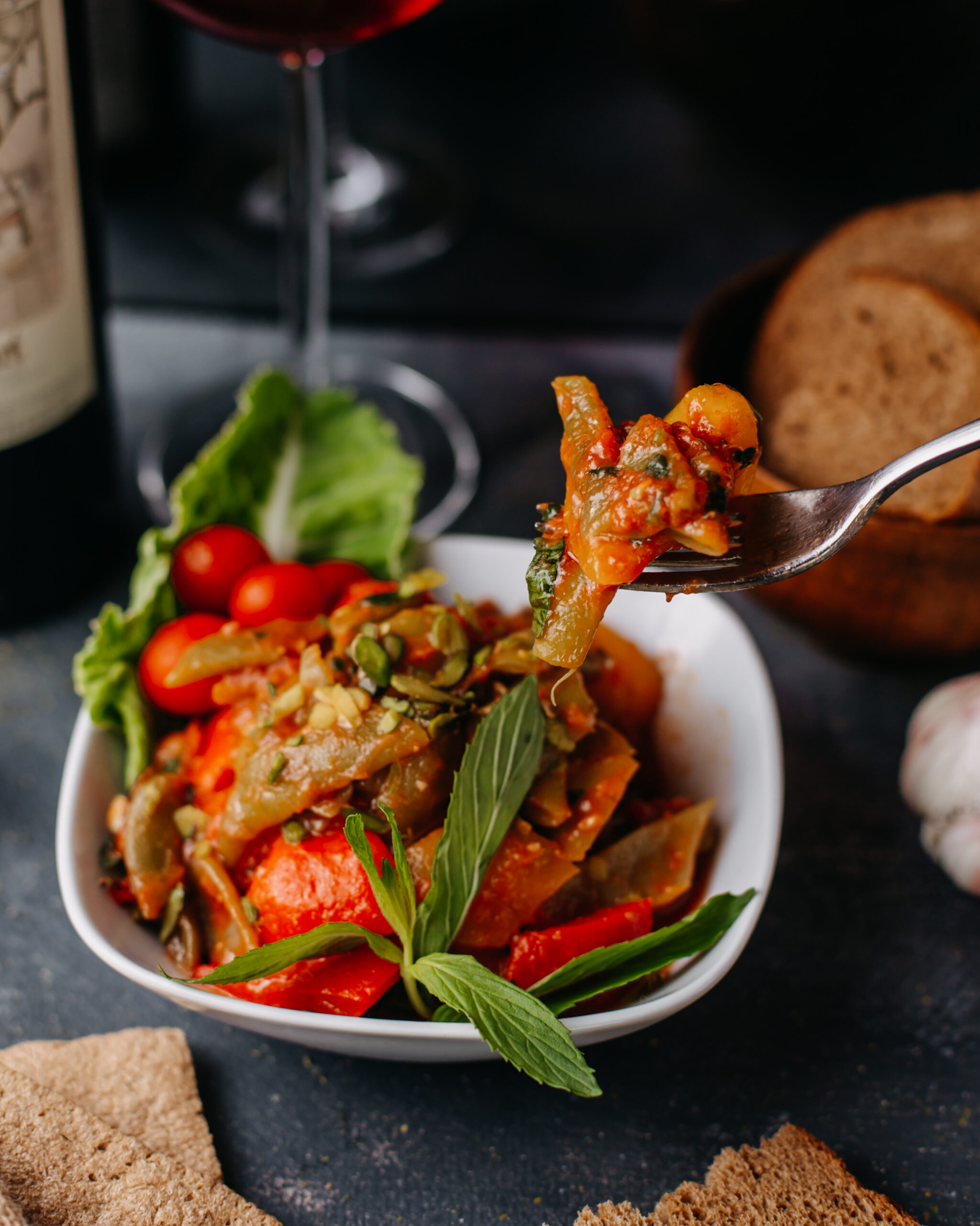 fried-meat-along-with-fried-vegetables-colorful-sliced-inside-white-plate-along-with-red-wine-bread-loafs-grey