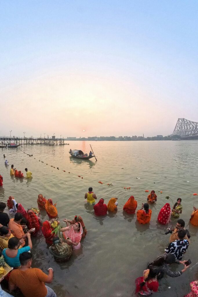 Devotees during Chhath Puja at the Ganges River in Kolkata, facing the sunrise.