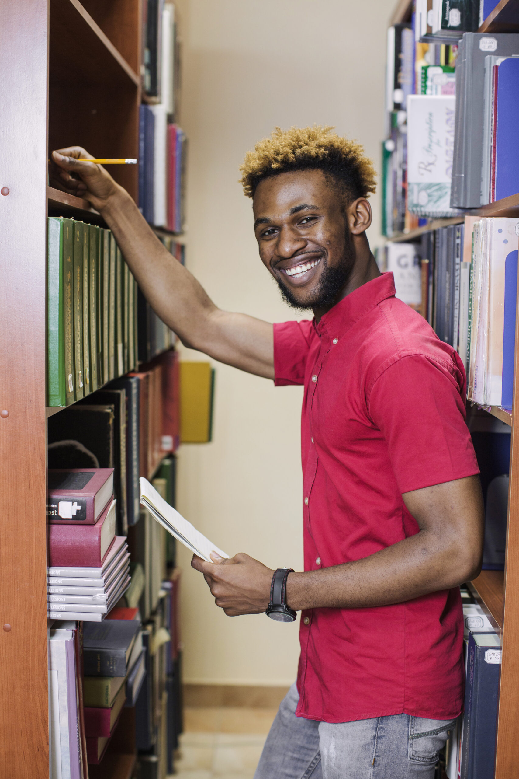 student-posing-library-smiling-camera