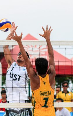 Beach volleyball action shot of two players competing at a tournament in Pasay, Philippines.